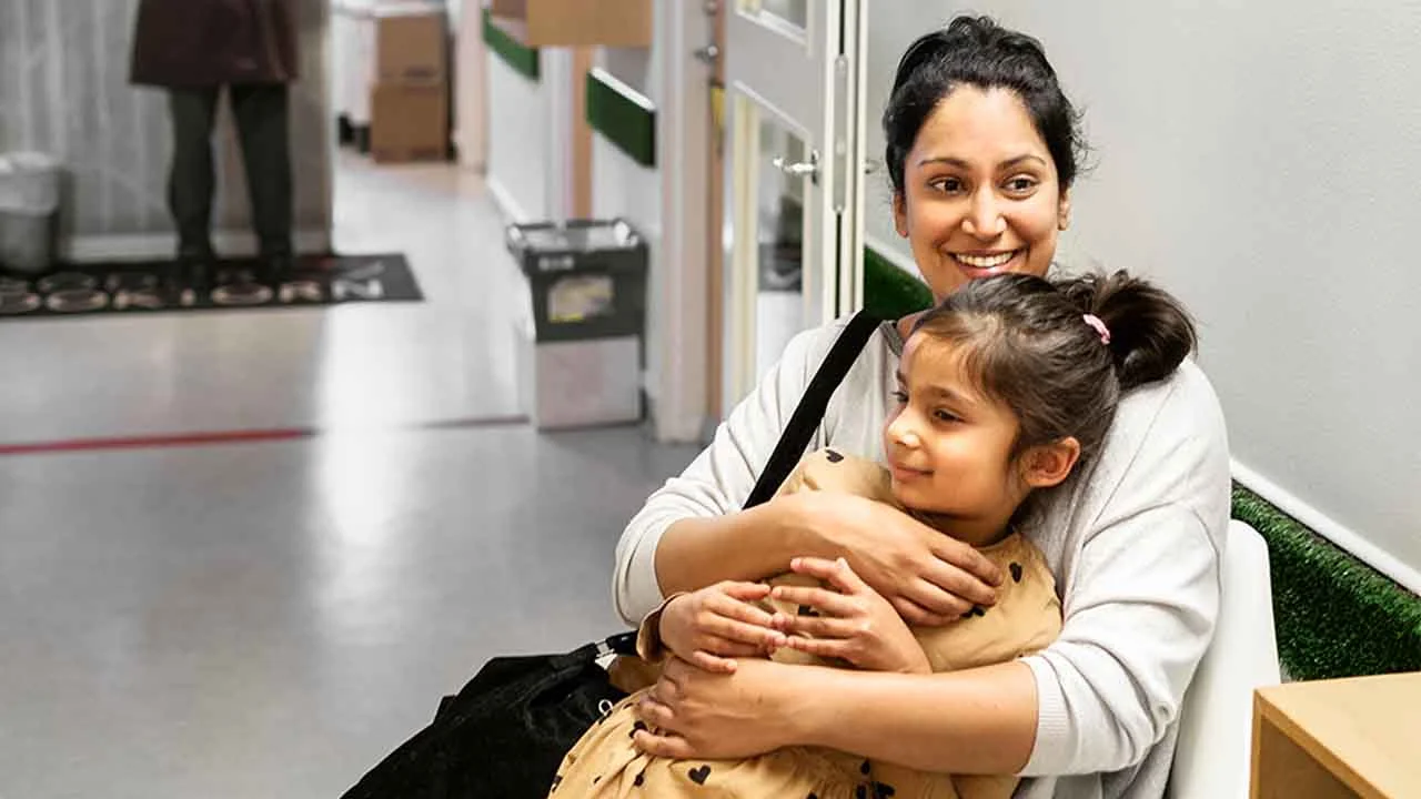 A woman is holding a child in her arms